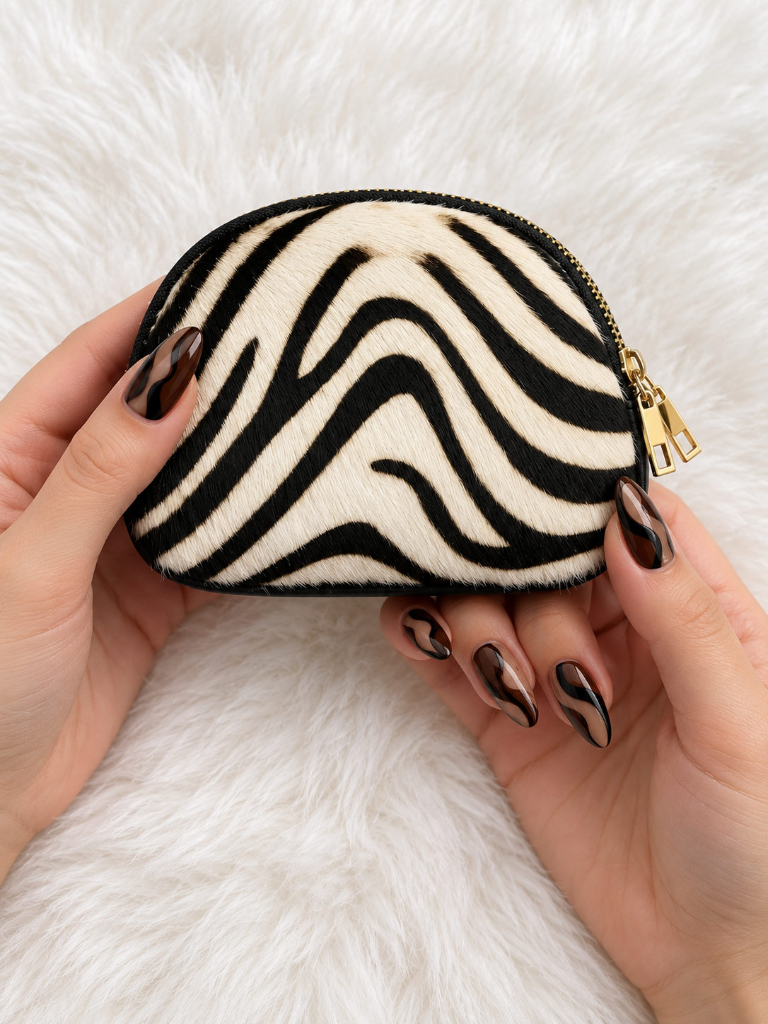 Monedero Zebra Chic — sostenido en manos con manicura