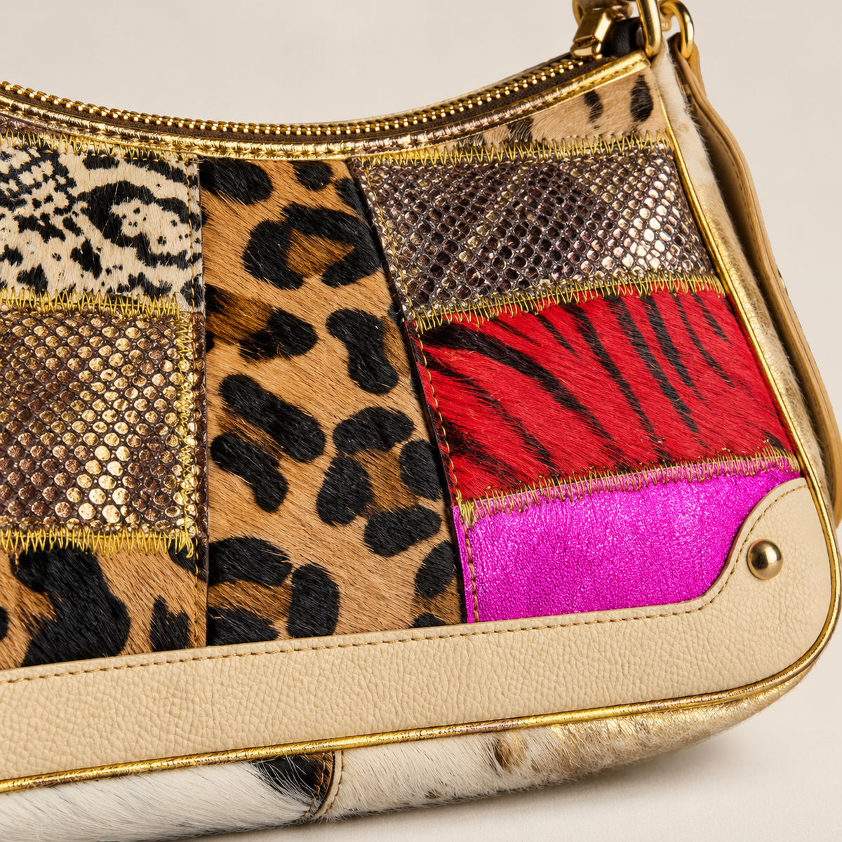Detalle de piel, estampados y acabados dorados del bolso Wild Glam