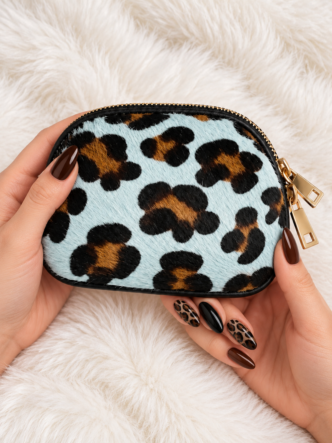 Monedero Blue Safari — sostenido en manos con manicura marrón y negra